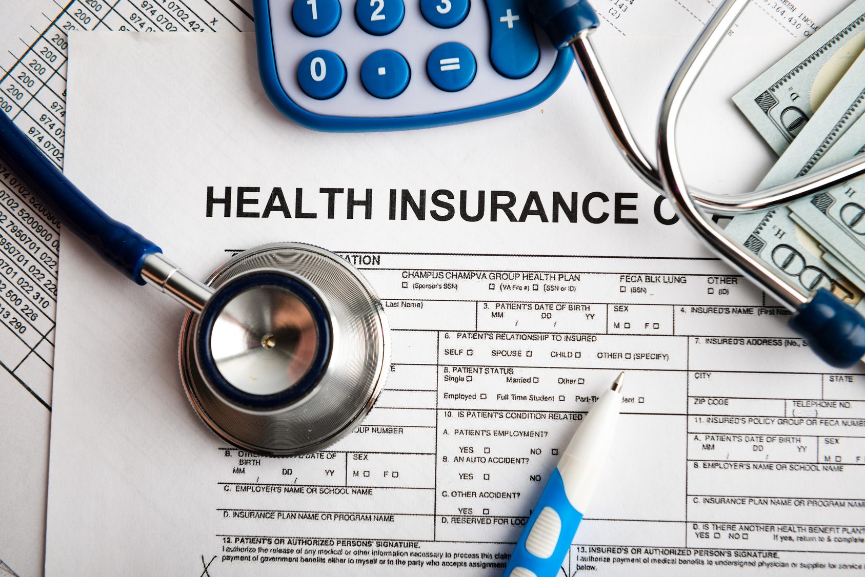 Health insurance application form with banknote and stethoscope